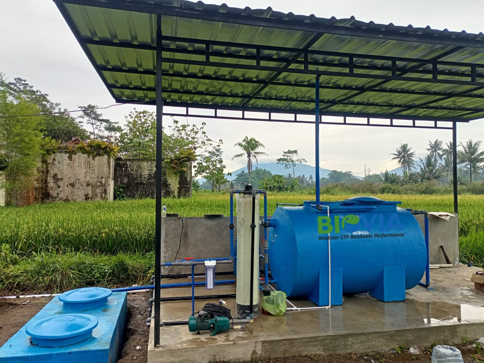 Instalasi BIOVIA Modular STP — Reliable Performance di lokasi klien dengan atap pelindung dan sawah hijau sebagai latar