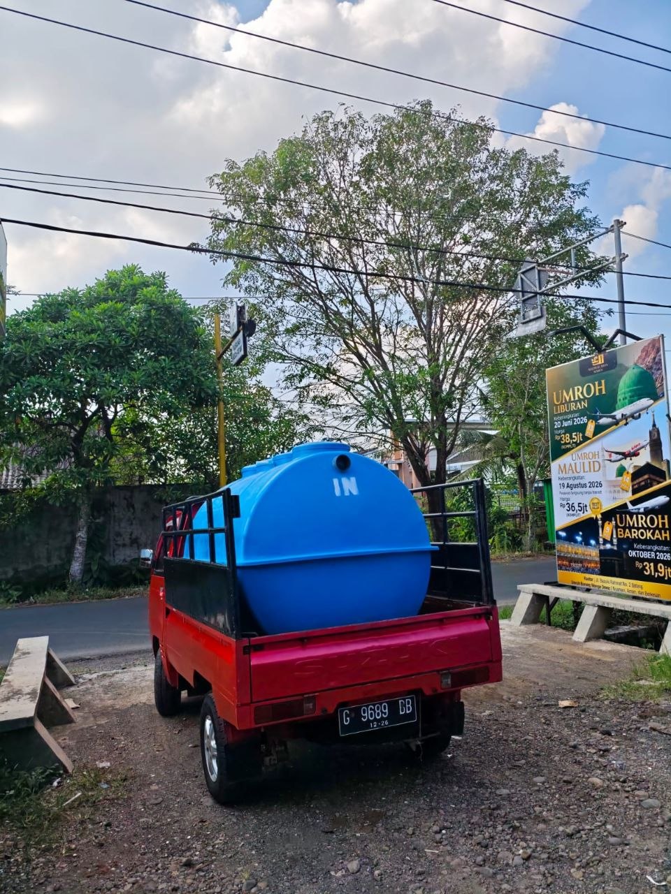 Pengiriman tangki BIOVIA fiberglass biru kapasitas kecil via truk Suzuki Tayo merah ke lokasi klien
